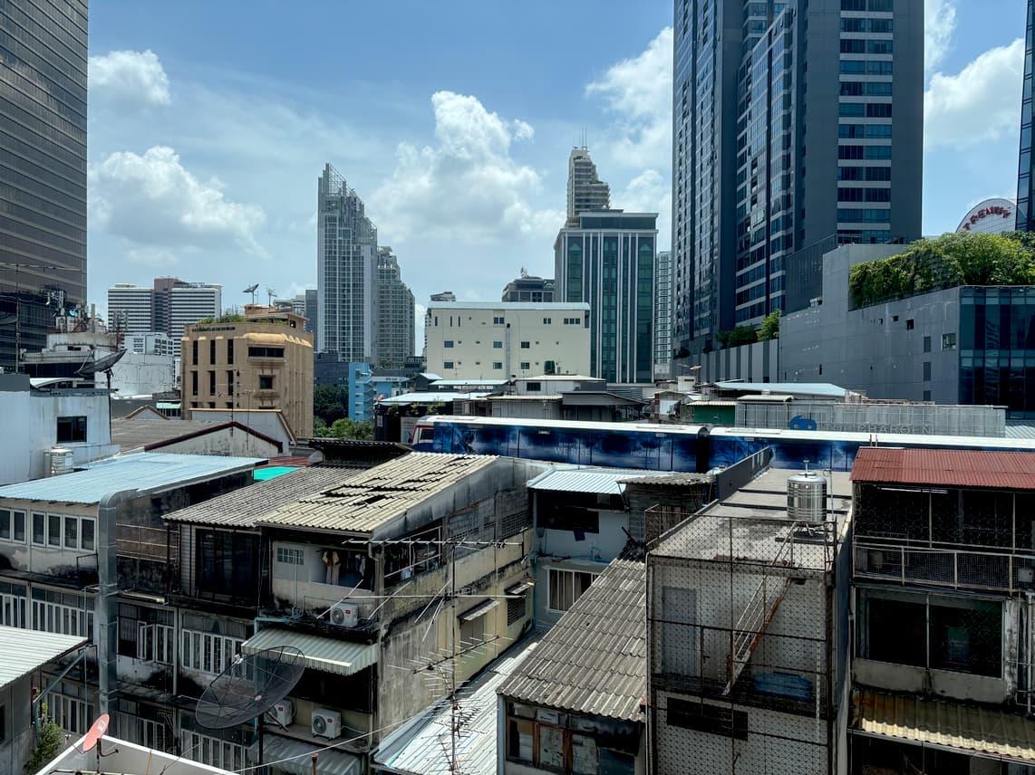 The BTS Skytrain in Bangkok seen between mid- and highrise buildings.