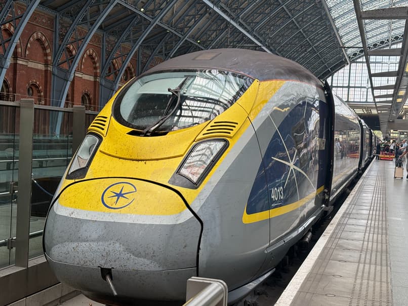 A front view of a yellow and gray Eurostar train at a station platform.