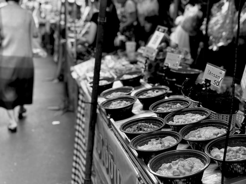 A street food stall selling prepared cups of rice with toppings.